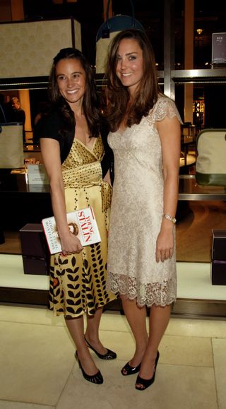 Kate and Pippa Middleton smiling wearing short dresses and holding a book at a 2007 book party