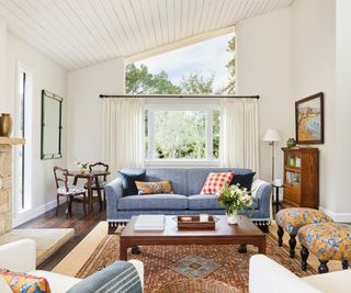 living room with blue sofa and patterned ottoman stools
