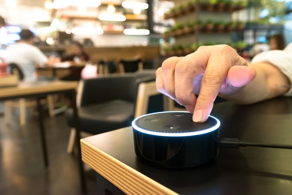 An Amazon Eco Dot being pressed by a user