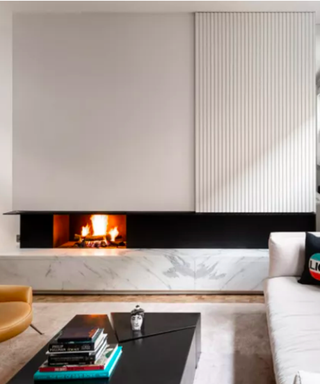 White living room colour scheme that includes a fireplace and panel that hides a TV