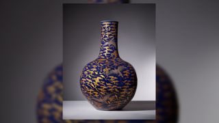 The image shows an 18th-century Chinese blue vase decorated with silver cranes and gold bats and clouds.