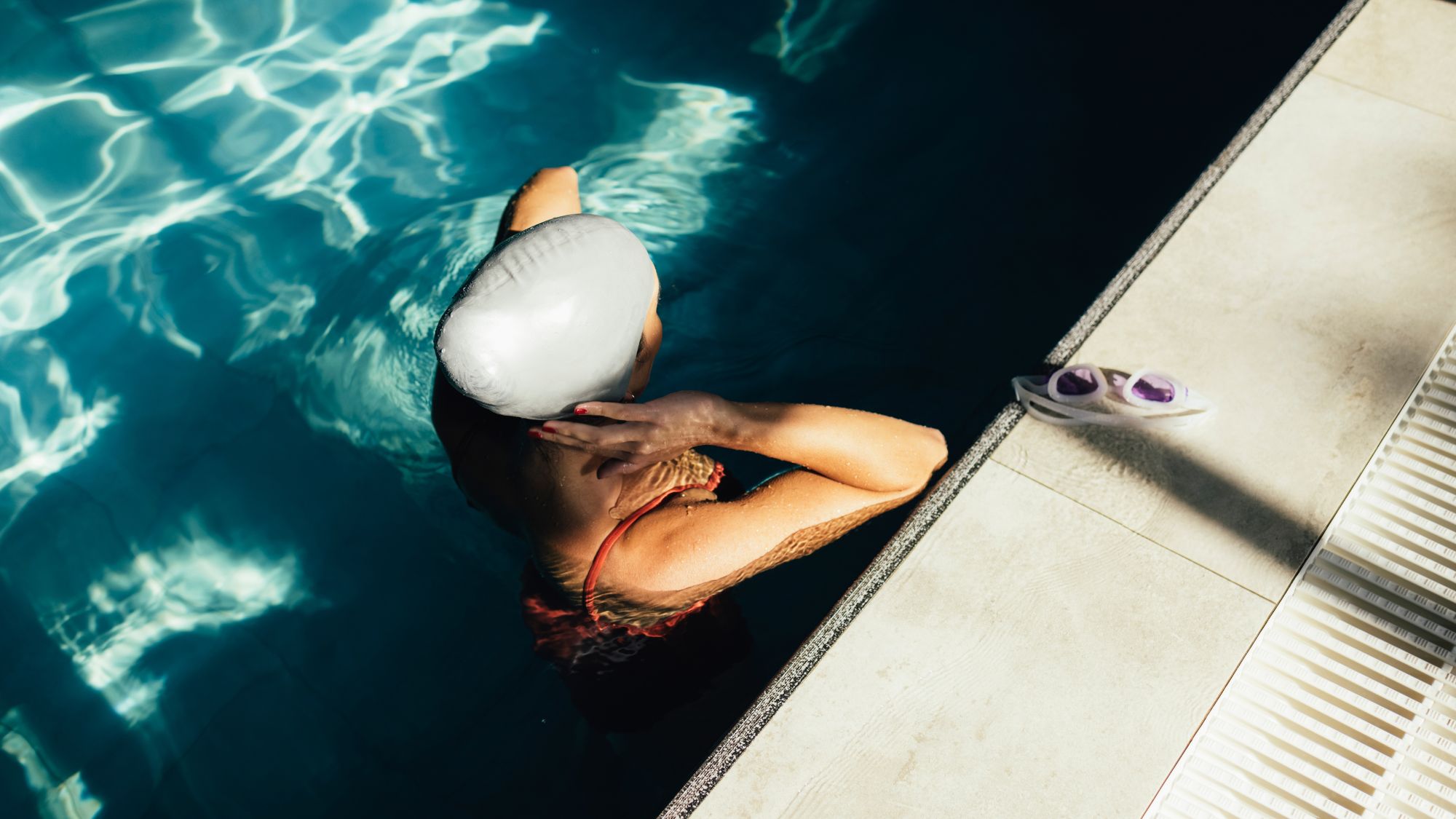 woman wearing swimming cap standing in pool