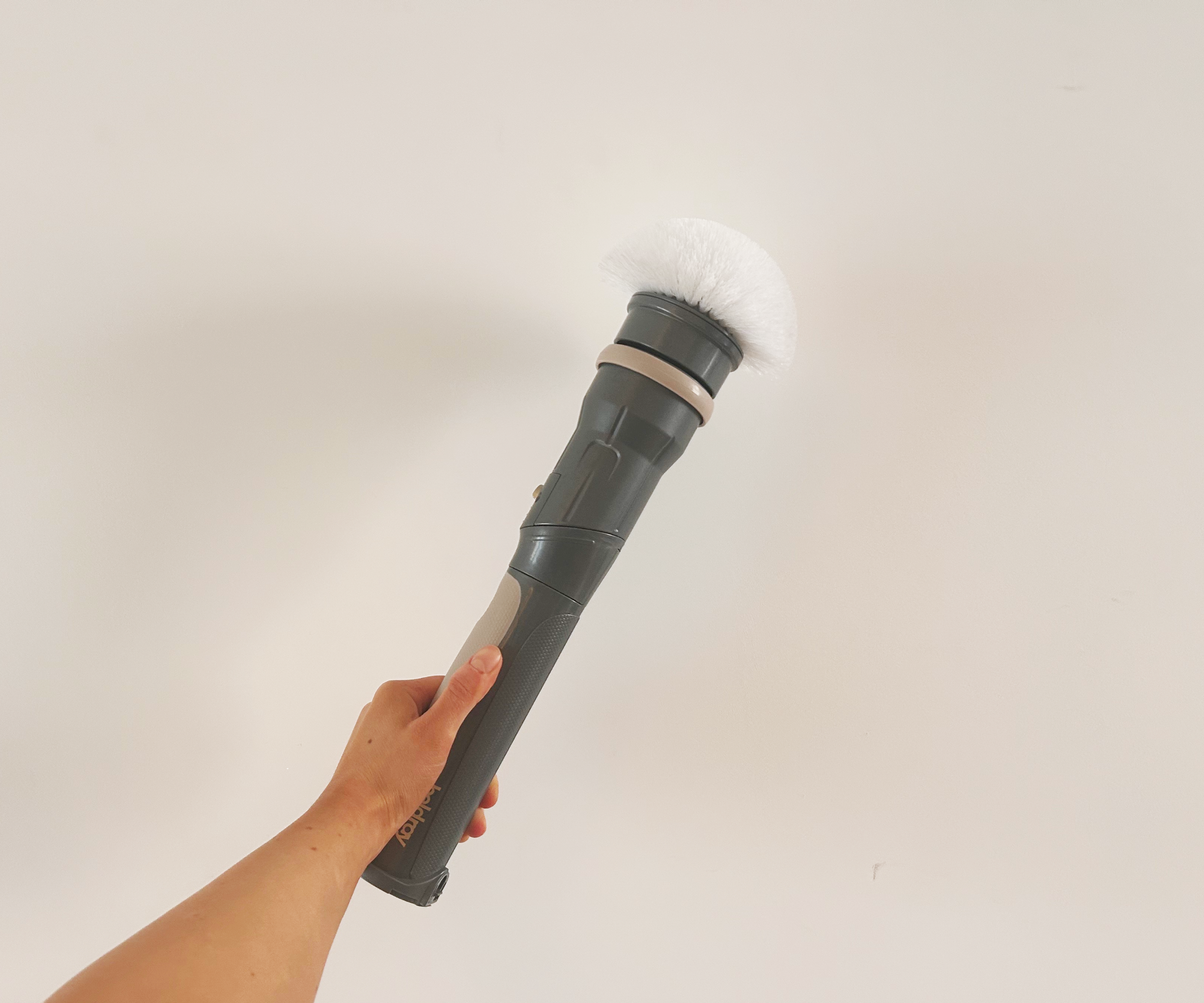 Megan's hand holding the Beldray shower cleaner in the small handheld form