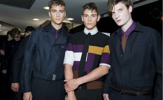 Three male models wearing work clothing by Salvatore Ferragamo in dark shades.