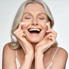 A woman rubbing a Face the Future skincare product on her cheeks