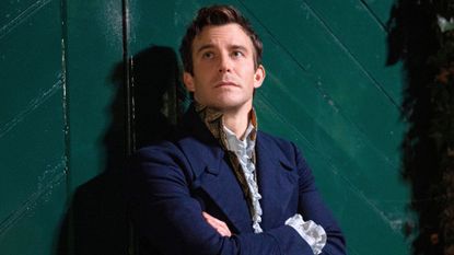 Benedict Bridgerton leans up against a wall