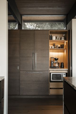 A built-in pantry with a microwave and coffee station