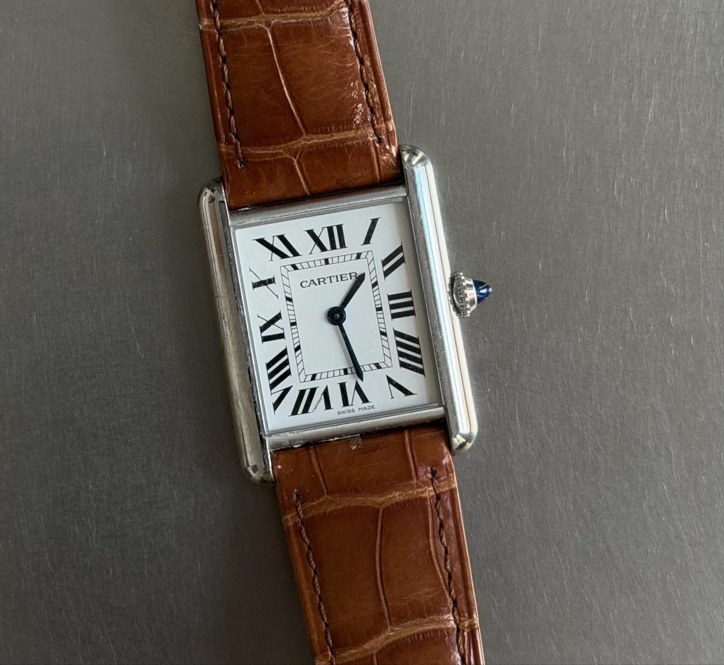 An image of @rikkekrefting wearing a Cartier Tank with a croc strap.