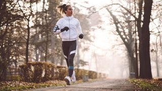 Running leggings deals. This image shows a woman wearing leggings running on an outdoor path.