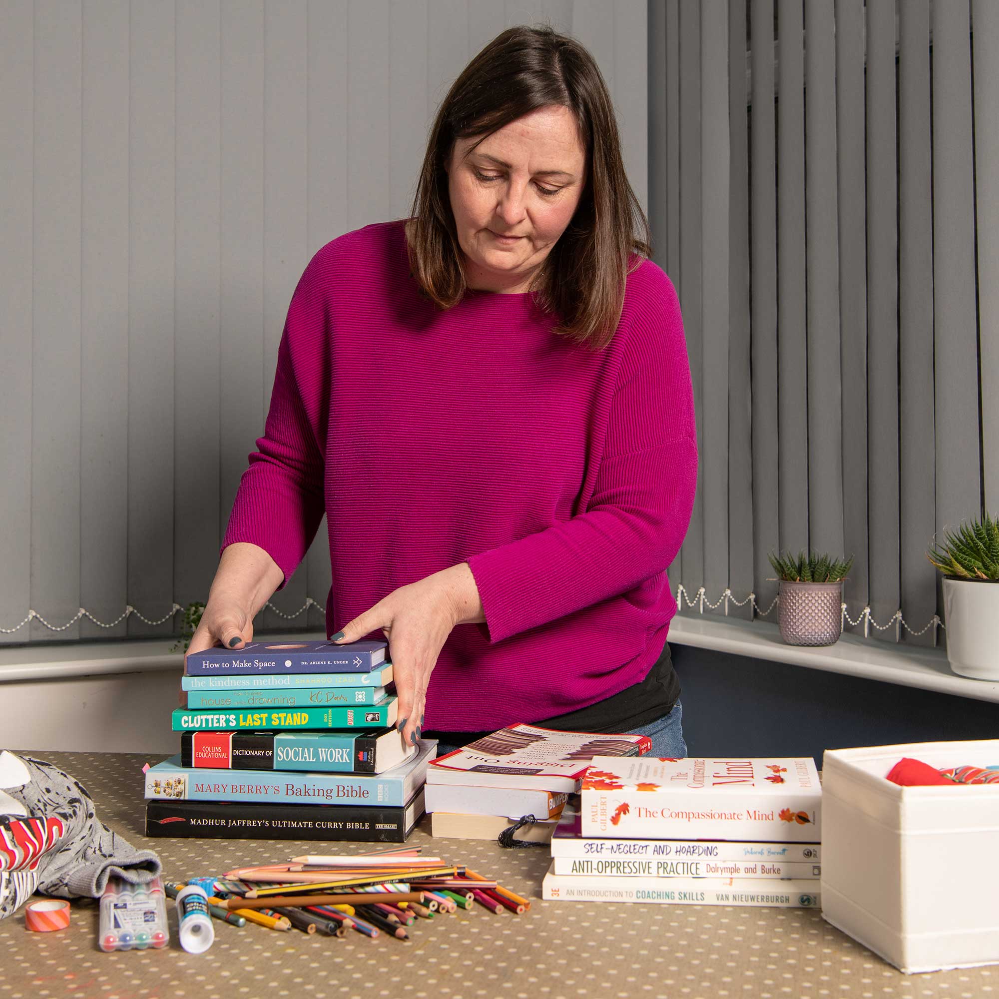 Lisa barrett profesional organiser decluttering a pile of books