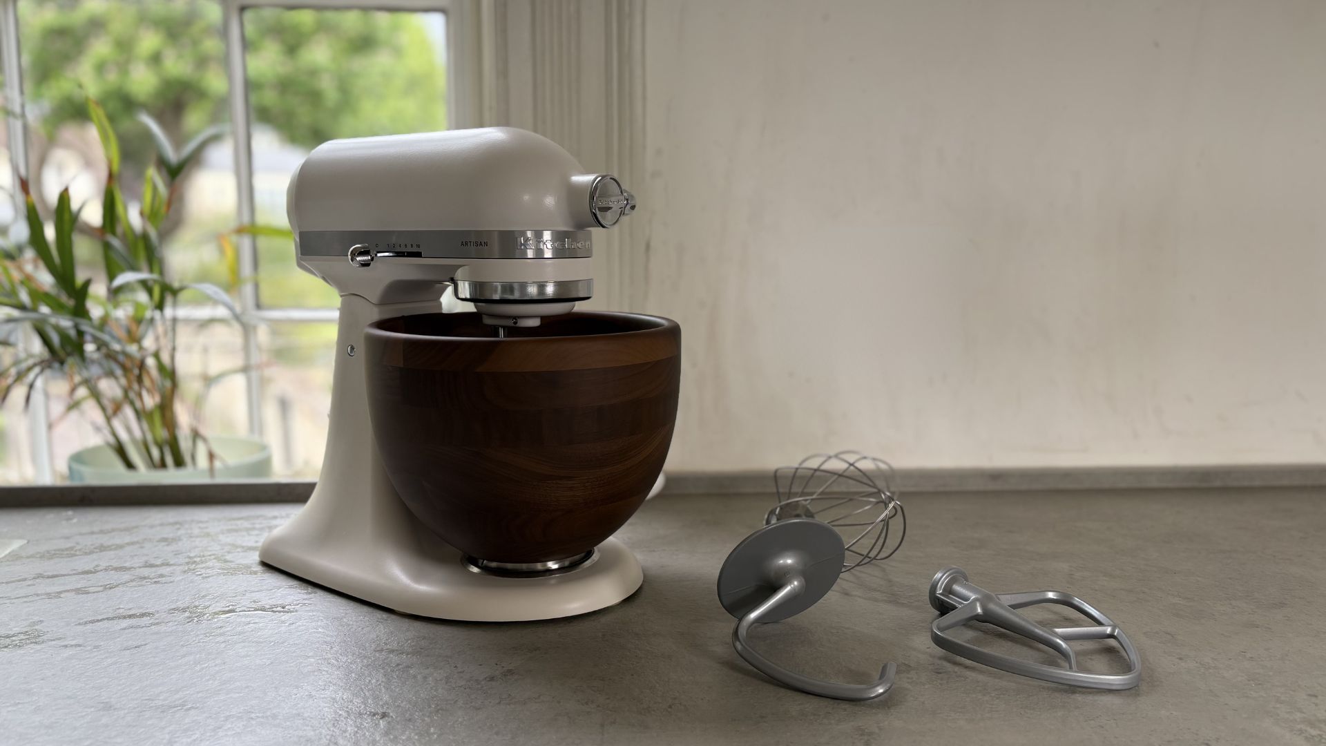 KitchenAid Artisan Stand Mixer with Wooden Bowl on the counter with accessories