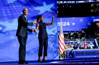 Former US President Barack Obama arrives to speak next to former US First Lady Michelle Obama during the Democratic National Convention (DNC).