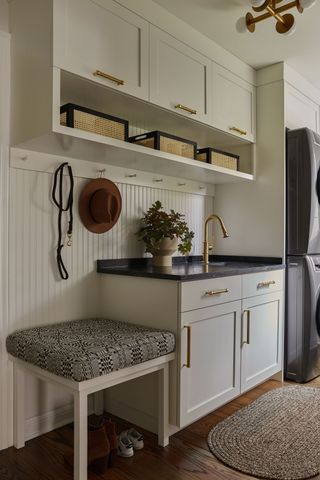 a laundry room with up-high storage and a sink