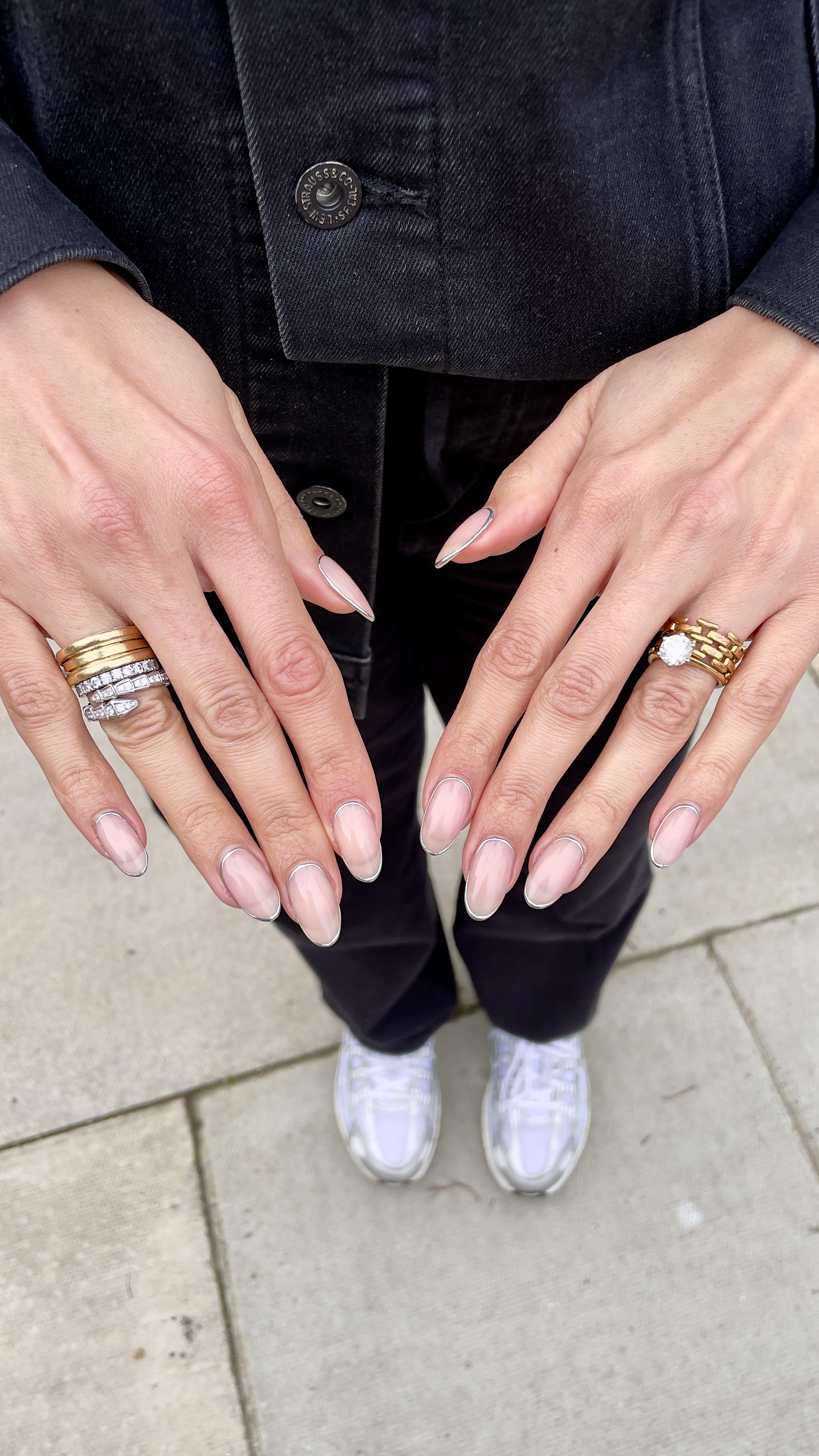 a photo of nawal al's hands showing a diamond engagement ring and chunky gold wedding band