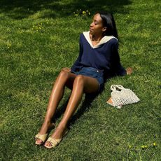 Woman wearing raffia J.Crew sandals in the grass