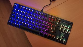 Roccat Vulcan TKL gaming keyboard out of its box with RGB lighting on positioned on a desk