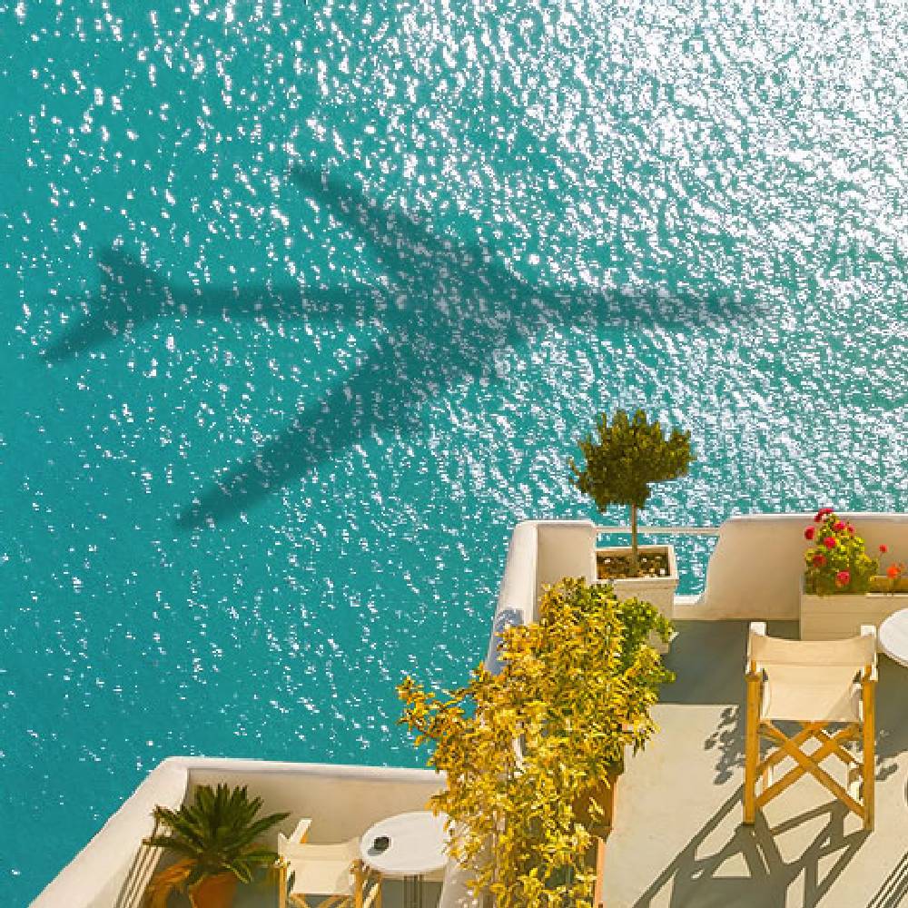 A blue ocean with the shadow of a plane. 