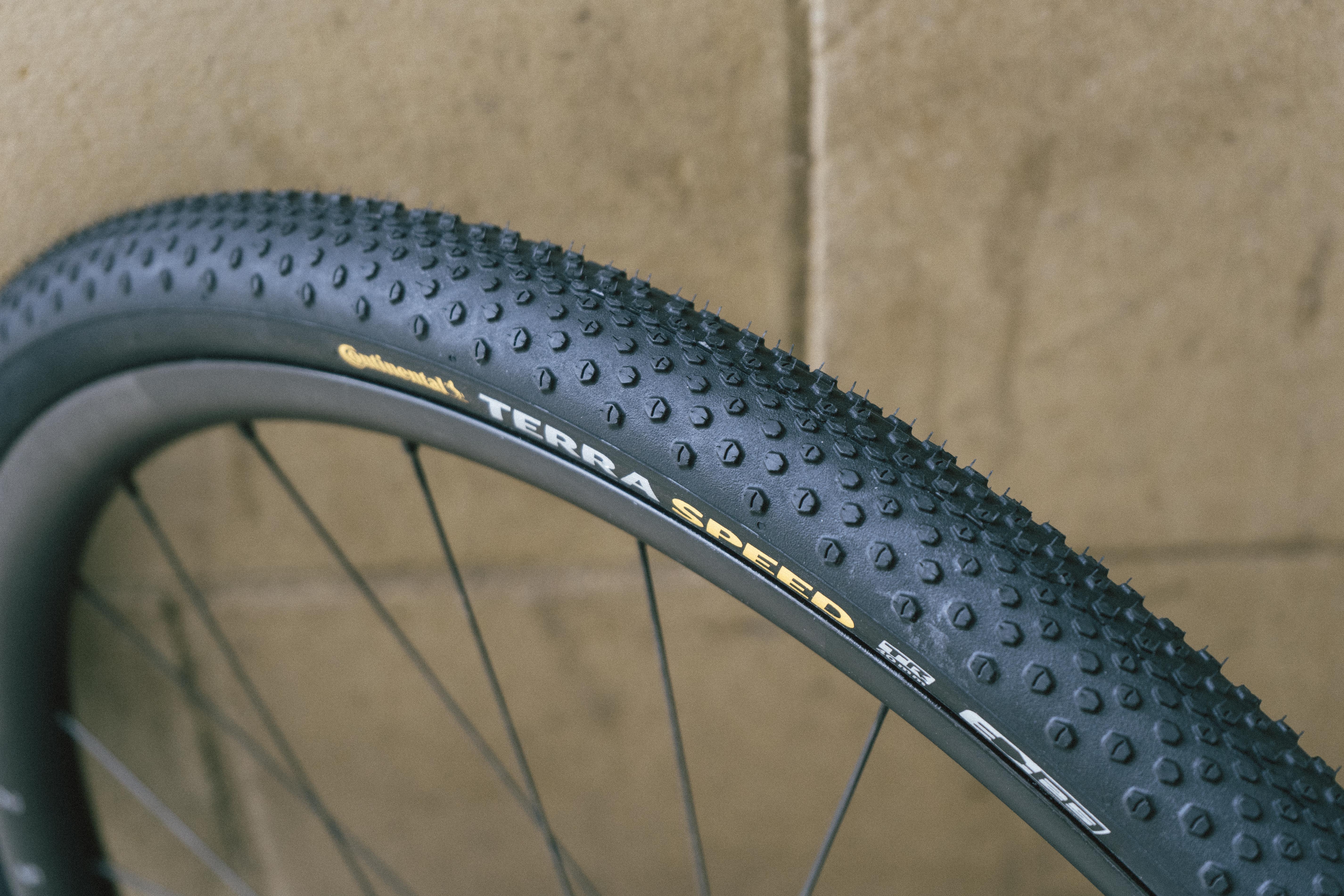 A black gravel tyre against a stone wall