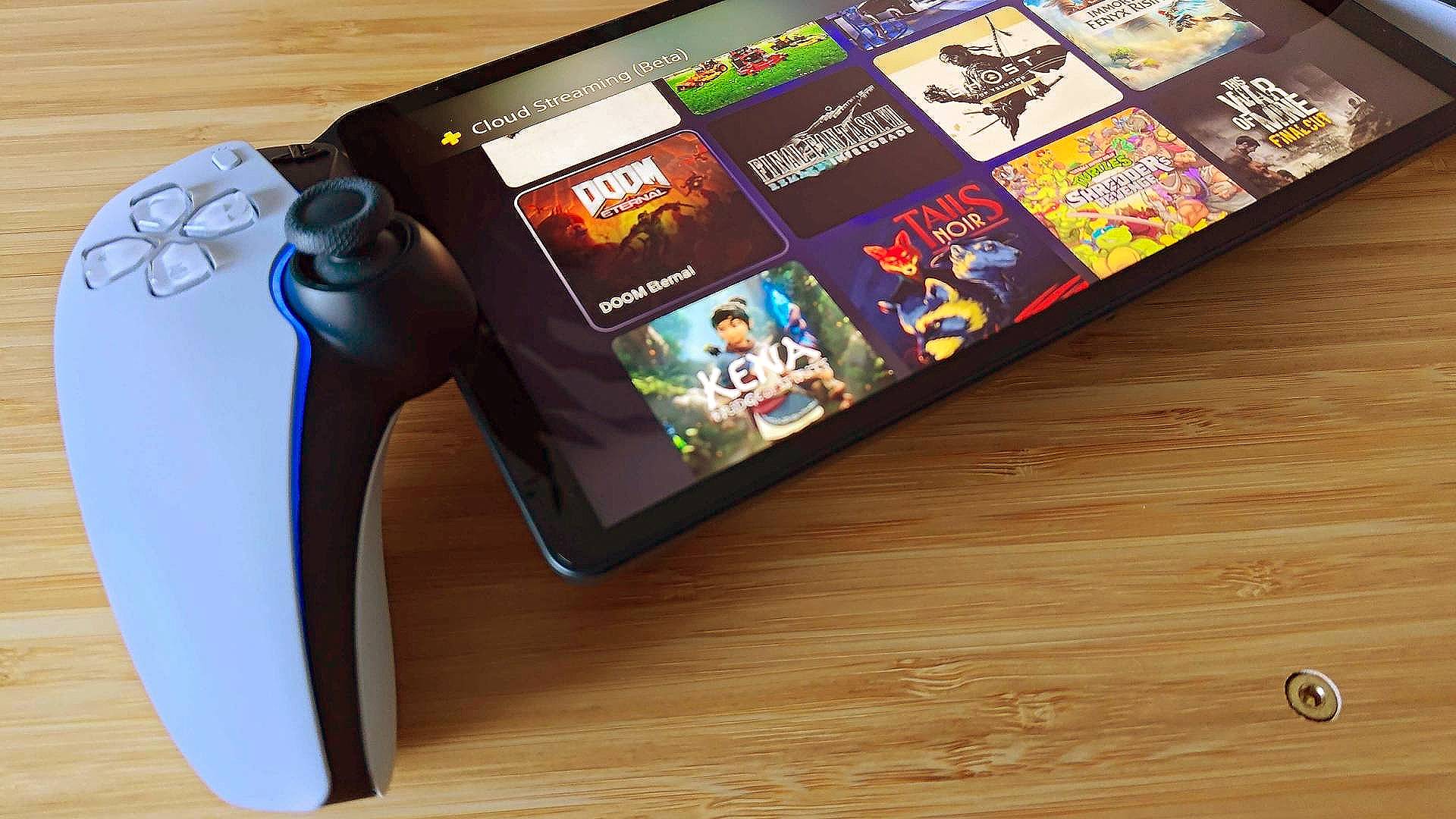 Close up of PlayStation Portal on woodgrain surface with cloud library on screen.