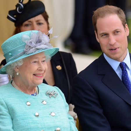 Queen Elizabeth in a turquoise coat sitting next to Prince William