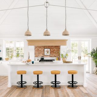 Modern white kitchen with pendant lights and breakfast stools
