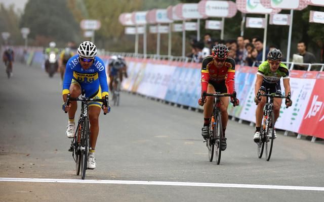 Rider's scattered as they cross the line.