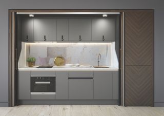 Gray kitchen cabinets set into alcove with sliding door