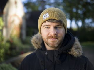 A man wearing a coat and a beanie hat