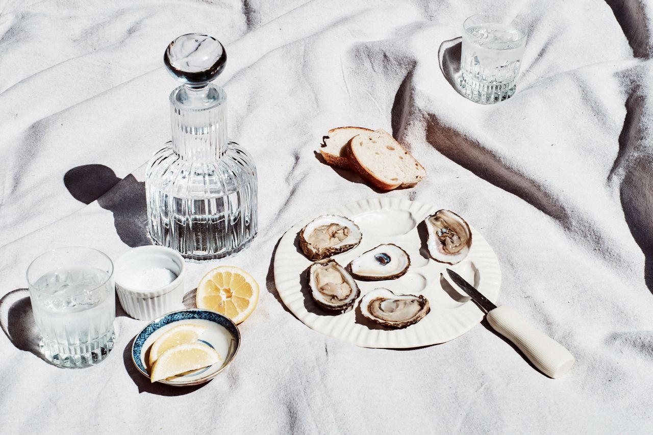 an oyster serving plate with oysters, bread and lemon