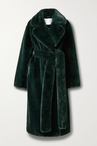 A belted faux fur coat on a plain backdrop