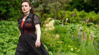 Margot Pue in a black dress in a garden as Amber in The Au Pair.