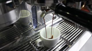 En Sage by Heston Blumenthal: The Oracle Touch håller på att brygga kaffe ned i en vit kopp.