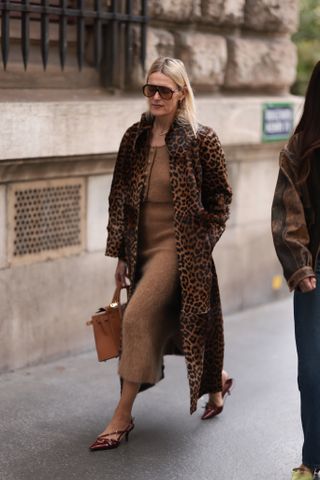 woman wearing leopard print coat, brown dress, and heels