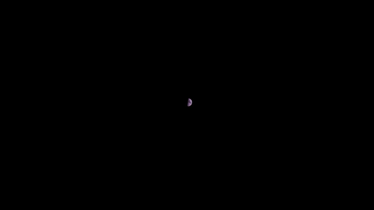 A wide shot showing a small half moon as photographed by the Fujifilm GFX100S II.