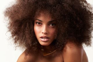 model Aliana King wears big curls and a gold Dior necklace.