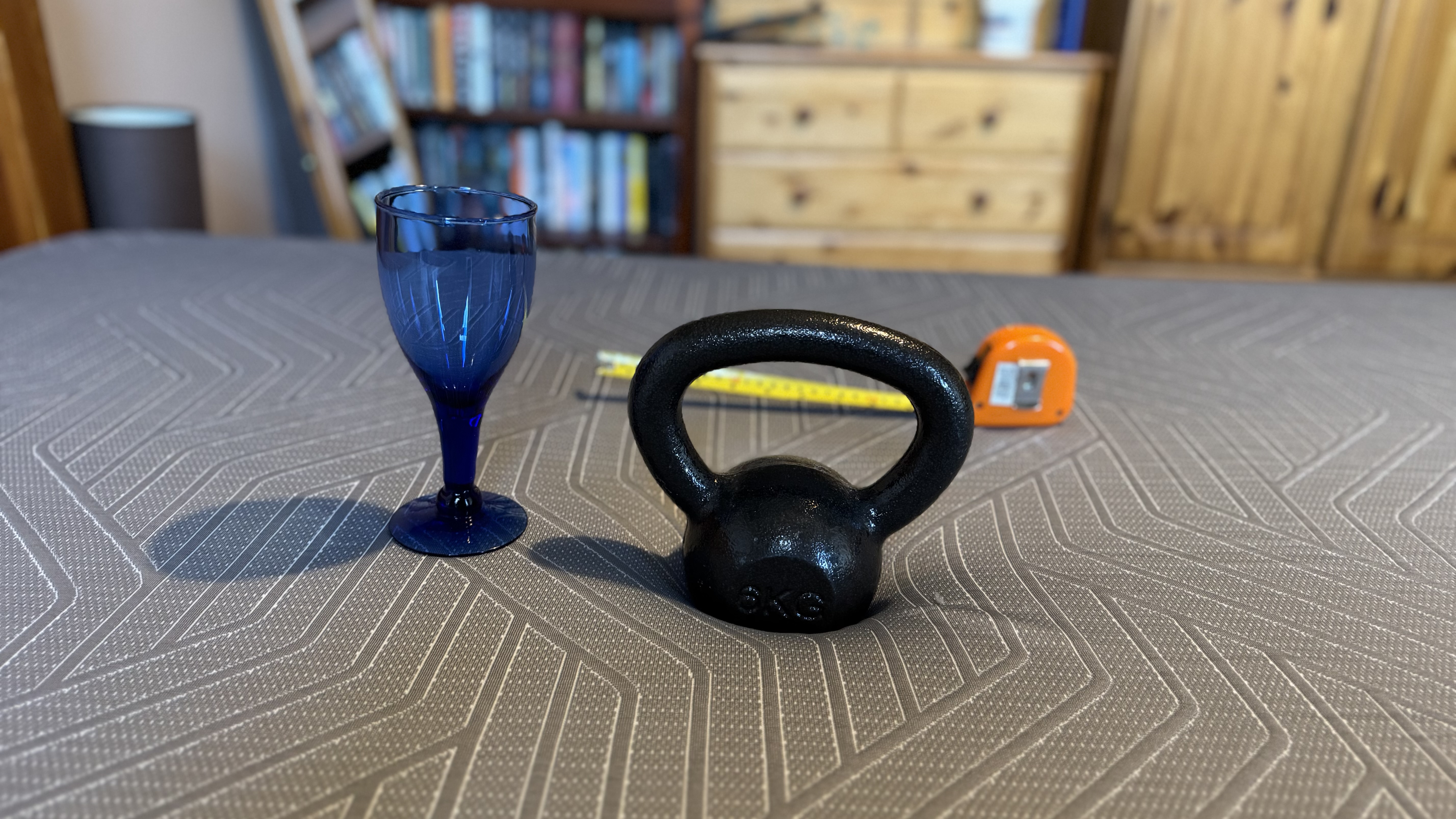 A wine glass, tape measure and weight to measure motion transfer on the EGOHOME Hybrid mattress.