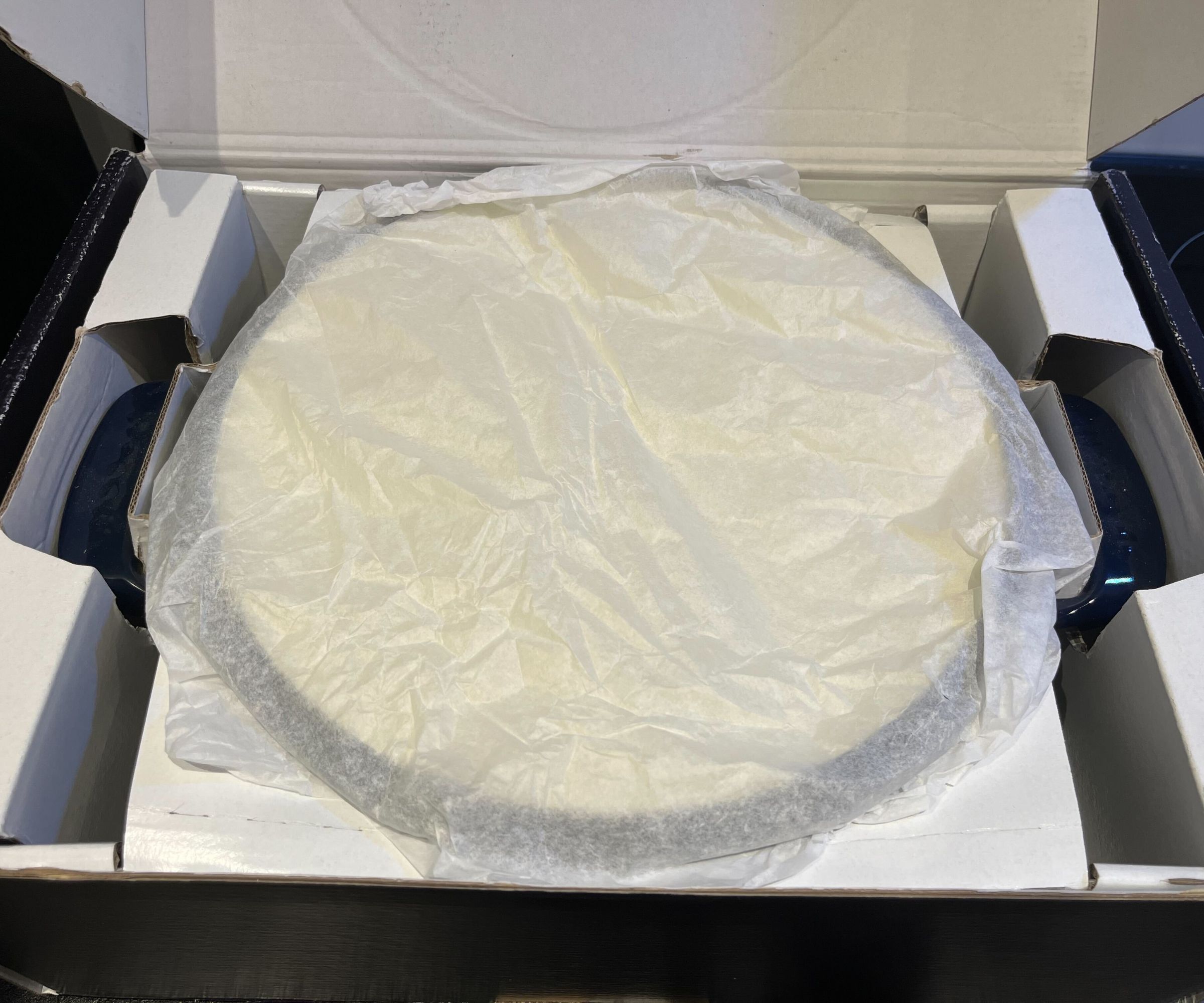 Made In Dutch Oven in the box, the lid covered with tissue paper
