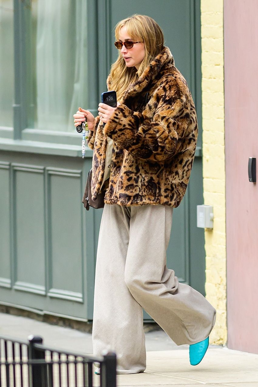 Jennifer Lawrence wearing a leopard faux fur coat, tan pants, and bright blue shoes in NYC