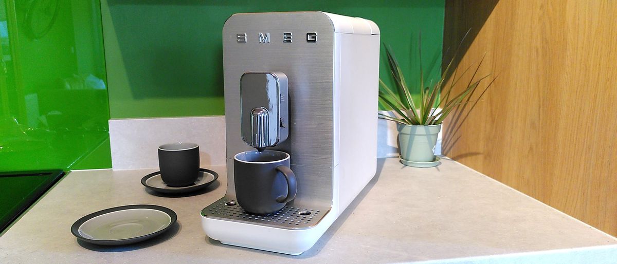 Smeg BCC13 coffee maker with cups on kitchen counter