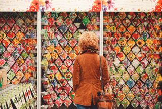 A woman looks at a wall of seed packets in a store