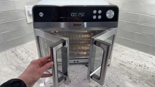 Ninja French Door Air Fryer and Countertop Oven on counter with hand opening door