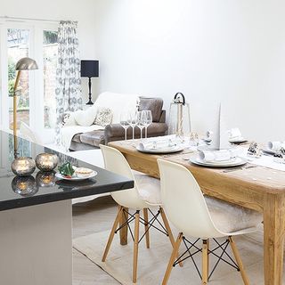 dinning area with white wall and wooden dinning table and chair