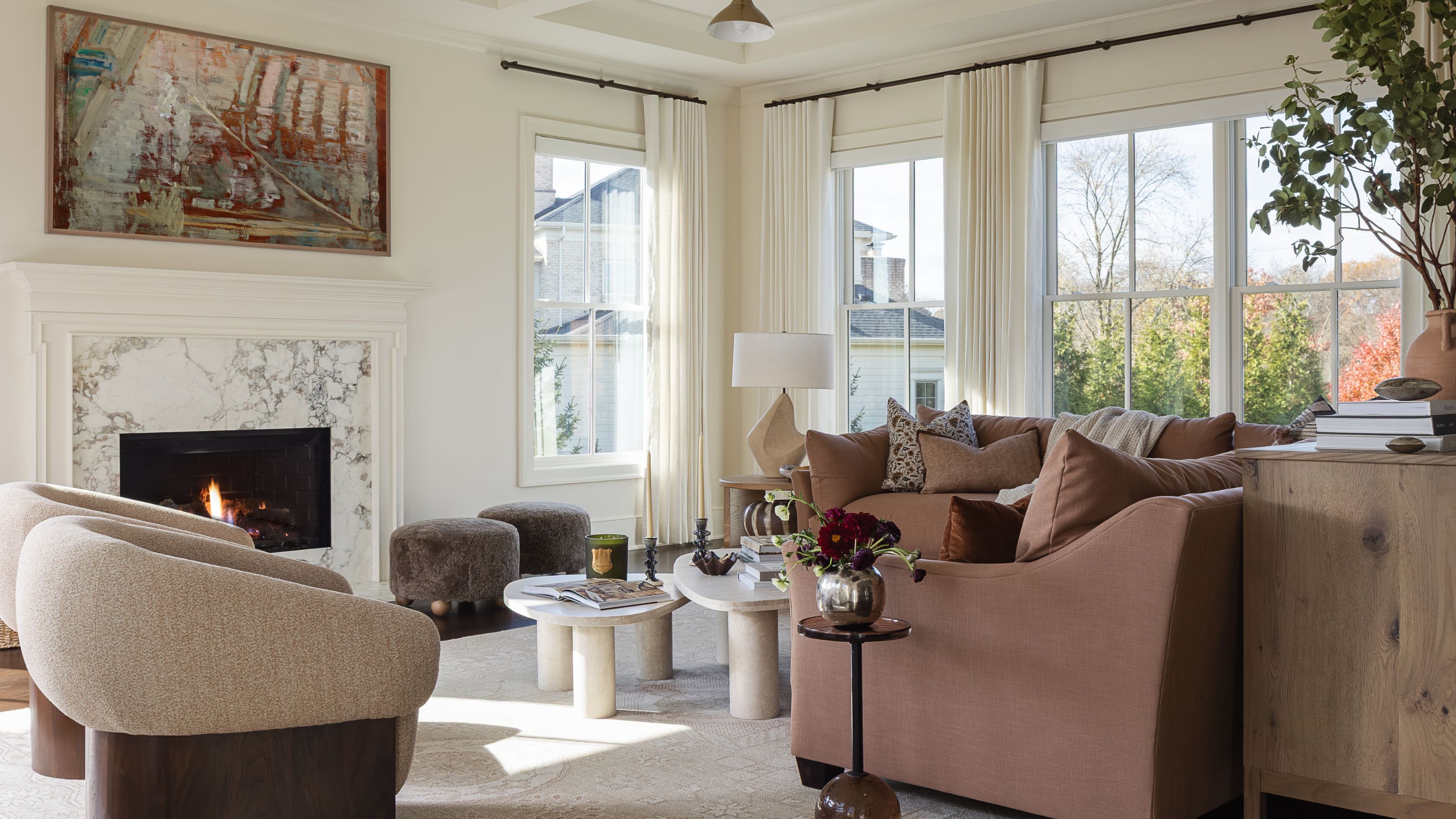 a soft neutral living room with marble fireplace and a large pink section sofa