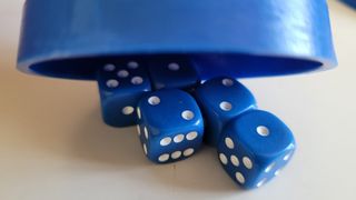 The blue dice and cup of the Perudo board game