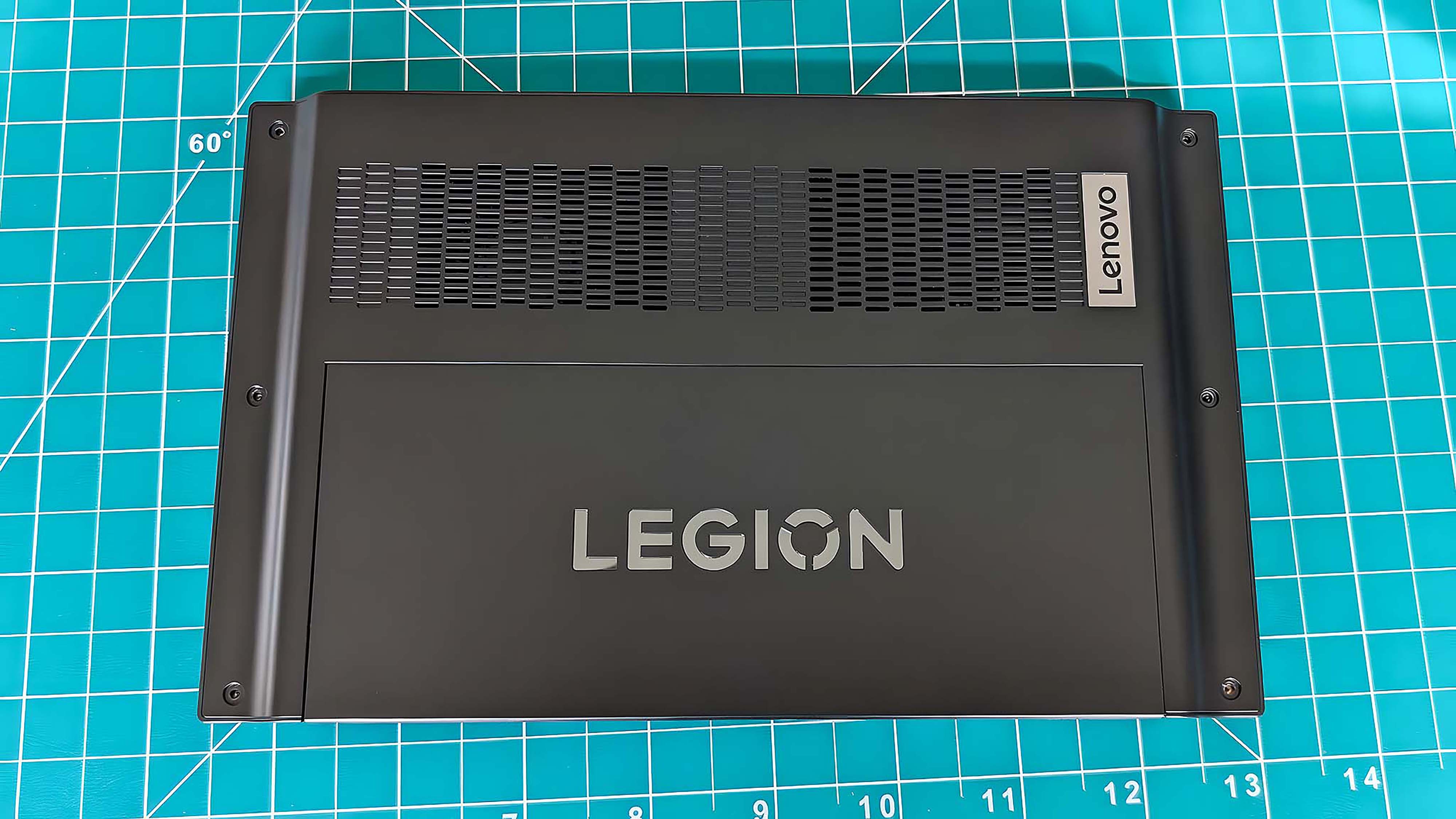 The back side of the Lenovo Legion Go while it is face down on a green mat.