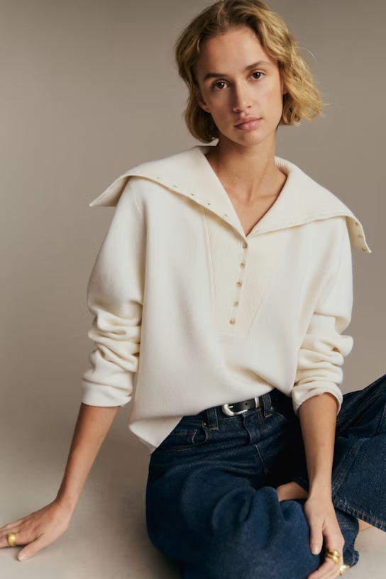 A model wearing a white sweater with a wide collar.