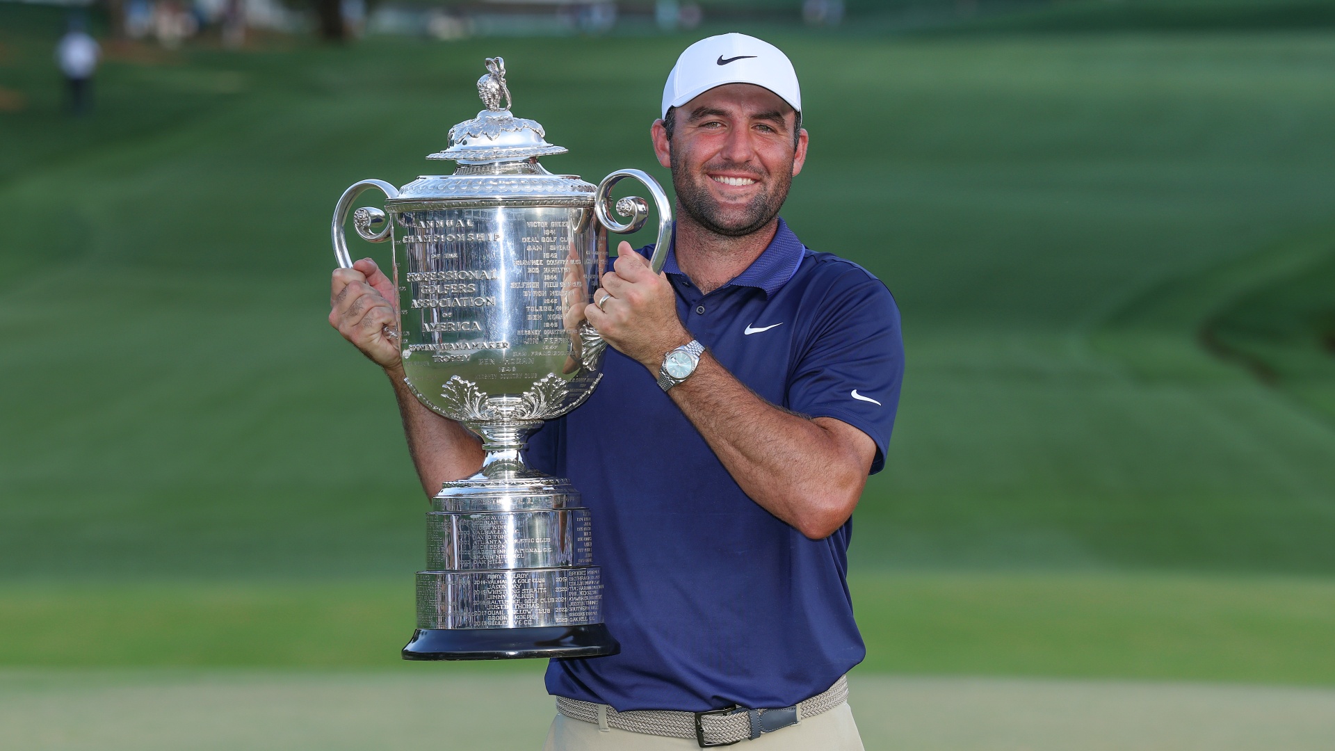 Scottie Scheffler holding the Wanamaker Trophy aloft after winning the PGA Championship in 2025
