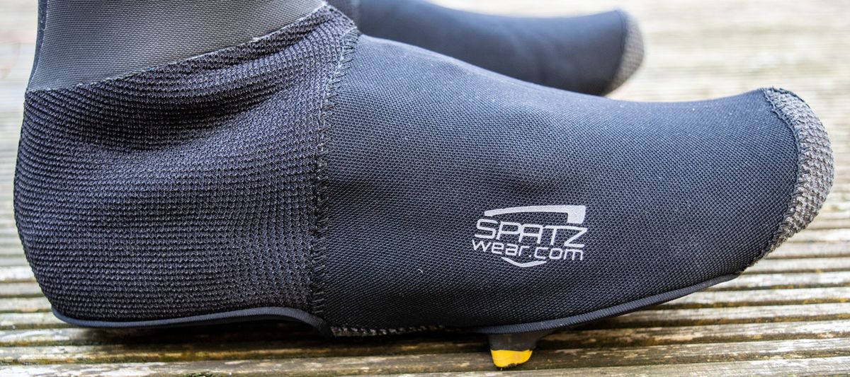 A rider wearing the Spatz Pro Stealth overshoe system on a wooden deck 