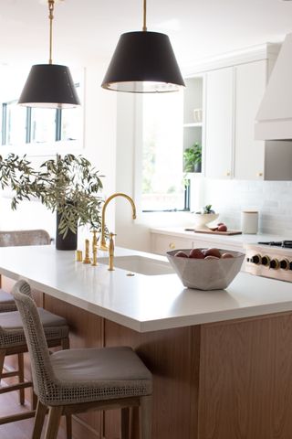 white kitchen and kitchen island with pendant lighting by K Interiors