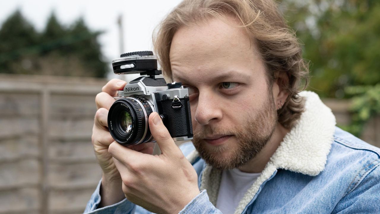 Man holding Nikon FM with Sekonic Twinmate L-208 mounted on hot shoe